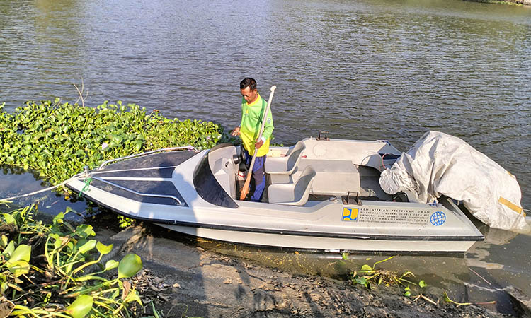 DIOPERASIKAN: Kapal boat milik BBWS Brantas yang dikerahkan untuk mengatasi enceng gondok yang menghiasi Embung Kertosari.