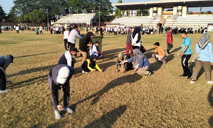 BERSIHKAN SAMPAH: Ratusan ASN Pemkot Probolinggo membersihkan sampah-sampah kecil di lapangan inti Stadioan Bayuangga usai senam Jumat pagi, (10/10).