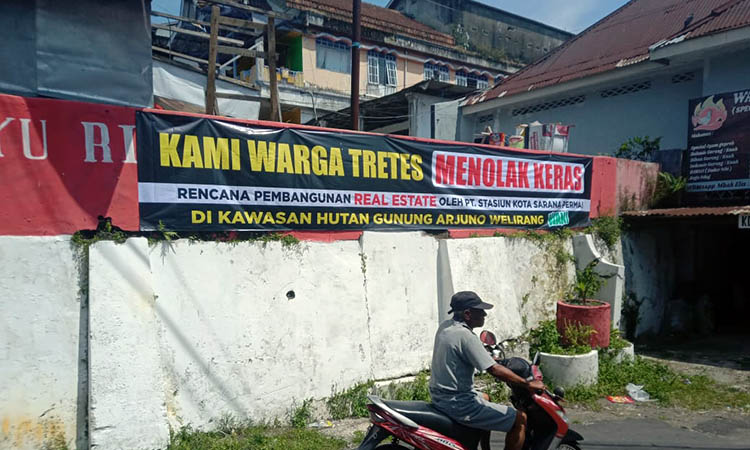MENOLAK KERAS: Spanduk dipasang warga sebagai bentuk penolakan terhadap rencana pembangunan real estate di kawasan hutan Gunung Arjuno-Welirang.