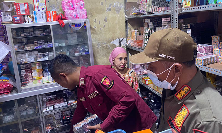 CARI: Petugas gabungan saat melakukan pengecekan terhadap salah satu toko yang dicurigai menjual rokok ilegal.