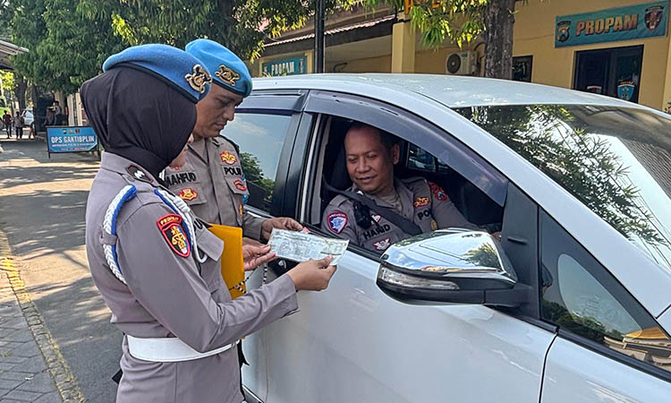 DIPERIKSA: Petugas Propam Polres Pasuruan saat melakukan pemeriksaan terhadap anggota yang masuk Mapolres Pasuruan. Hal ini dilakukan, sebagai langkah penegakan ketertiban dan disiplin anggota.