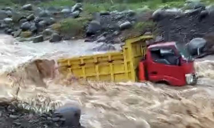 Kondisi truk muat batu yang terjebak di aliran sungai Pancarglagas Pakuniran yang debitnya mendadak deras saat turun hujan.
