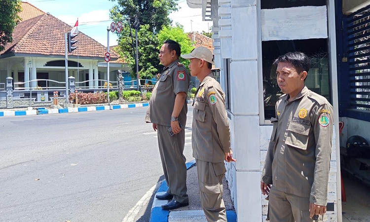 SIAGA: Petugas Satpol PP saat berjaga di salah satu persimpangan yang ada di Kota Pasuruan. Langkah ini dilakukan, untuk antisipasi adanya anjal, pengamen dan yang lain, berkeliaran dan meminta uang.
