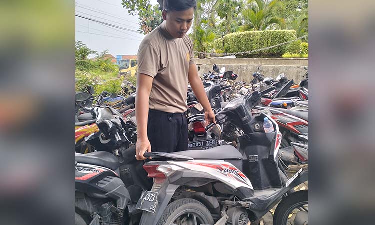 BARANG BUKTI: Anggota satlantas saat mengamankan motor Honda Beat yang menabrak pelari di Taman Dayu Pandaan.