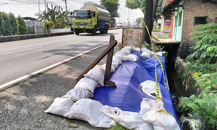 JALAN NASIONAL: TPT tepi jalan nasional di Dusun Arcopodo, Desa Kepulungan, Kecamatan Gempol yang sudah ditutup terpal setelah longsor.