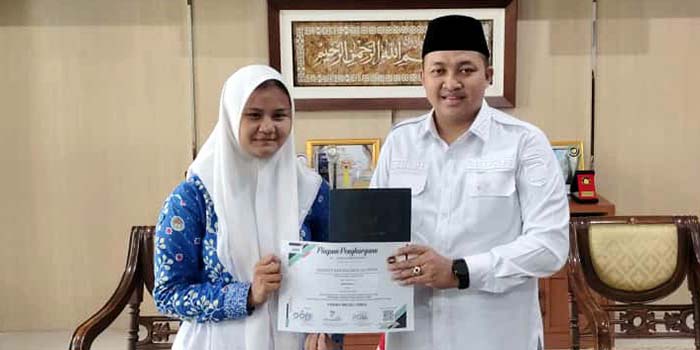 DIUNDANG BUPATI: Rhenate Kartika Paksi Sulfianto, 16, berbincang dengan Bupati Pasuruan H.M. Rusdi Sutejo yang mengundangnya bertemu, beberapa hari setelah meraih medali emas.