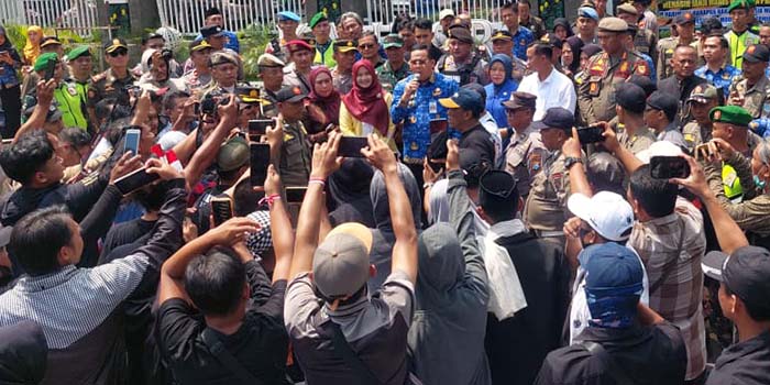 TEMUI MASSA: Wali Kota Probolinggo dr Aminuddin (pegang mik) dan Wawali Ina Dwi Lestari saat menemui pendemo di depan kantor Pemkot, Selasa (28/10).