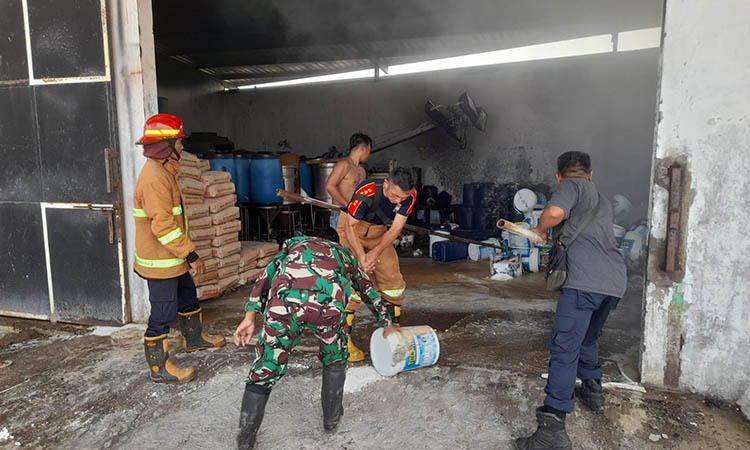 SEBELUM PADAMN: Personel damkar yang dibantu TNI memadamkan api di gudang penyimpanan kaporit di Dusun Landengan, Desa Penambangan, Kecamatan Pajarakan.