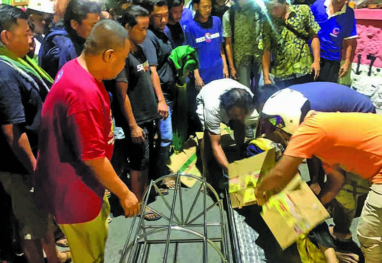 EVAKUASI: Petugas ambulans dari Dinas Sosial dan PPPA Kota Probolinggo mengevakuasi jenazah Tafrin, Selasa (28/10) malam.
