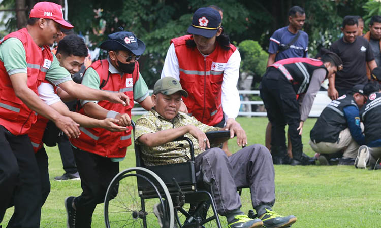 GERAK CEPAT: Personel BPBD mengevakuasi warga yang terjebak dalam kepungan banjir dalam simulasi bencana banjir yang digelar di kantor Pemkab Probolinggo.