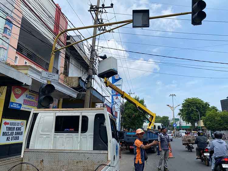 PERBAIKAN: Petugas Dishub Kota Probolinggo saat melakukan perbaikan pada traffic light di simpang tiga King, Kota Probolinggo, Kamis (30/10) siang