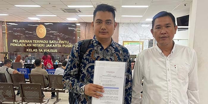 Kuasa hukum eks karyawan PTKL memperlihatkan berkas saat mendaftar berkas gugatan.