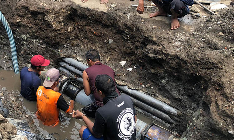 IKUT TERDAMPAK: Petugas Perumdam Tirta Bayuangga saat melakukan perbaikan di titik pipa yang terdampak pengerukan di Jalan Soekarno Hatta, Kota Probolinggo, Sabtu