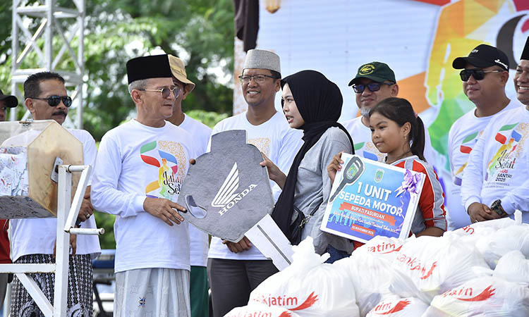 BERUNTUNG: Pemenang hadiah undian motor gratis di acara Jalan Sehat Santri tampak senang setelah diberikan hadiah oleh Wakil Bupati Pasuruan, HM Shobih Asrori.