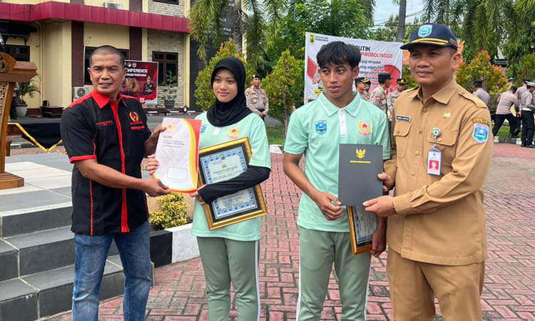 BUAH AKSI HEROIK: Mohammad Danil Azizil Rosiqin dan Yuliana Novita, dua atlet arung jeram yang jadi korban begal, mendapat penghargaan di Mapolres Probolinggo.