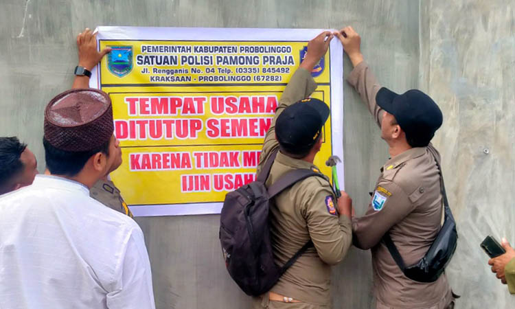 SEGEL: Personel Satpol PP saat melakukan penutupan gudahg tembakau di Dusun Krajan, Desa Jabung Candi, Paiton, Rabu (5/11).