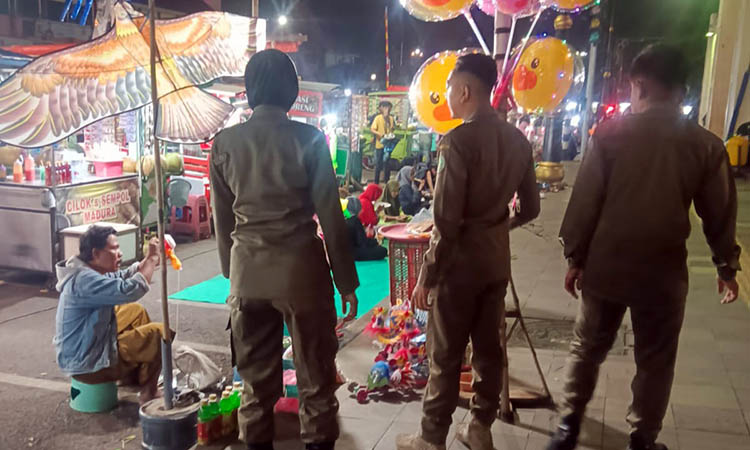 RAZIA: Petugas saat melakukan monitoring di wilayah Alun-Alun Pasuruan. Penertiban dilakukan, lantaran kedapatan PKL yang melanggar.