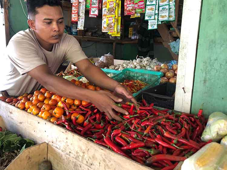 BERJUALAN: Salah satu pedagang di Pasar Baru, Abdullah menunjukkan cabe merah besar yang dijualnya, Minggu (2/11)