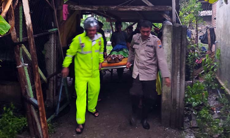 EVAKUASI: Petugas saat membawa jenazah Sugiarto yang ditemukan meninggal di kawasan kolam ikan.