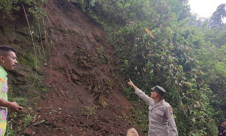 BERSIH-BERSIH: Personel TNI-Polri bersama warga melakukan pembersihan material longsor yang menutupi jalan di Puspo setelah longsor, Kamis (6/12) pagi.