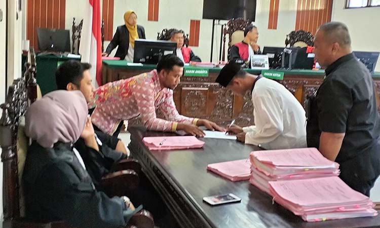 DIVONIS 14,5 TAHUN: Terdakwa Didik saat menandatangani berkas di PN Kraksaan.
