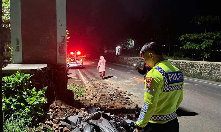NAHAS: Petugas saat memantau kondisi motor korban yang alami ringsek parah usai tabrak gapura.
