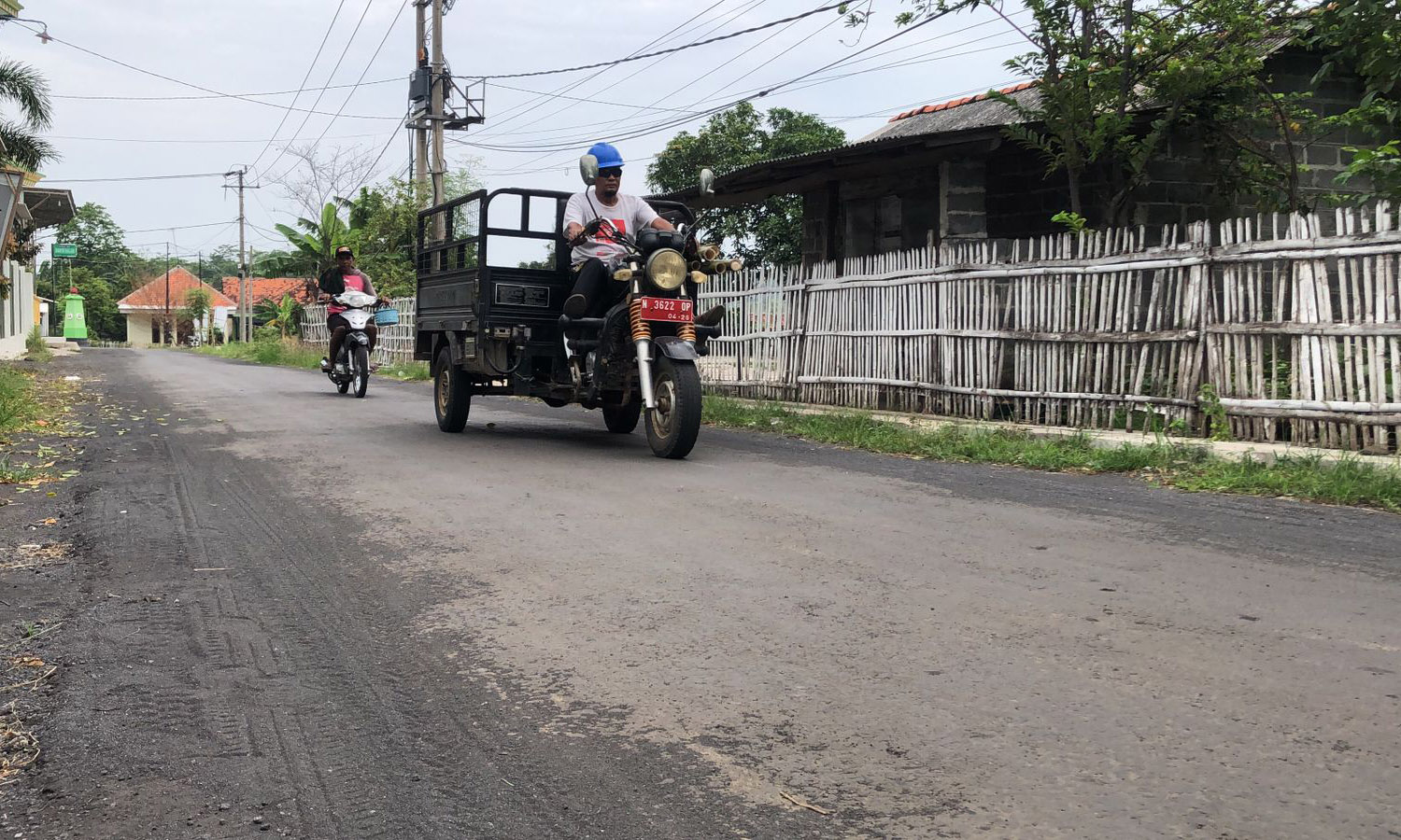 NYAMAN: Sejumlah masyarakat saat melintas di jalan yang telah diaspal kembali di Desa Watuwungkuk, Kecamatan Dringu, Kabupaten Probolinggo, Senin (10/11)
