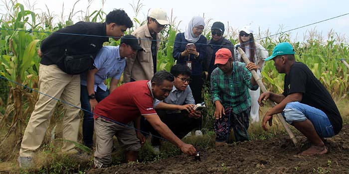 TEKNOLOGI: Rombongan BI Malang mempraktikkan langsung cara kerja alat uji tanah didampingi Ketua Poktan Rowo Makmur Satu, Wasis Hartono bersama anggotanya.