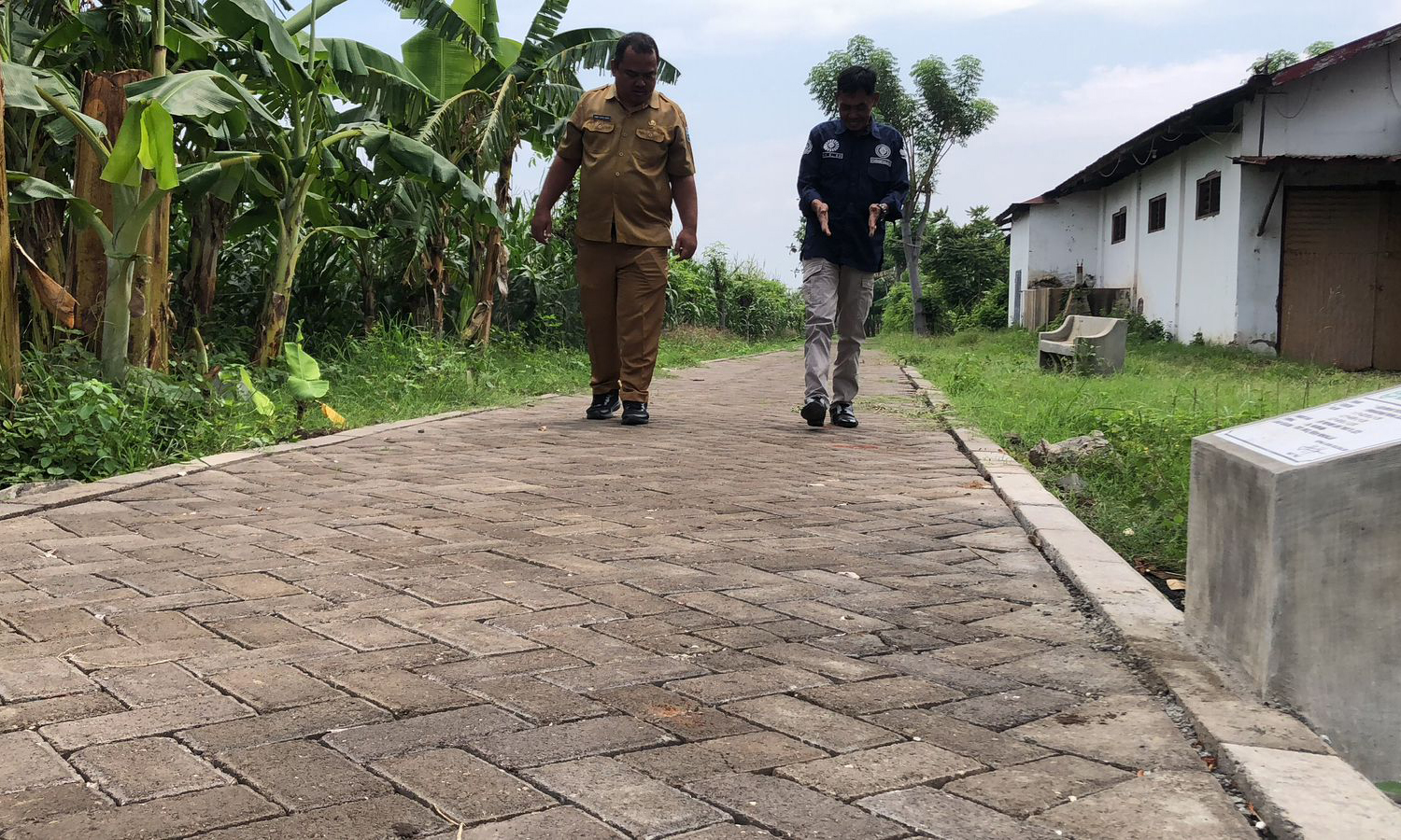 NYAMAN: Sekretaris Desa Kalisalam Ahmad Choirul Anwar (kiri) dan Pendamping Desa Kecamatan Dringu Ali Sujoko (kanan) mengecek hasil pembangunan jalan paving.