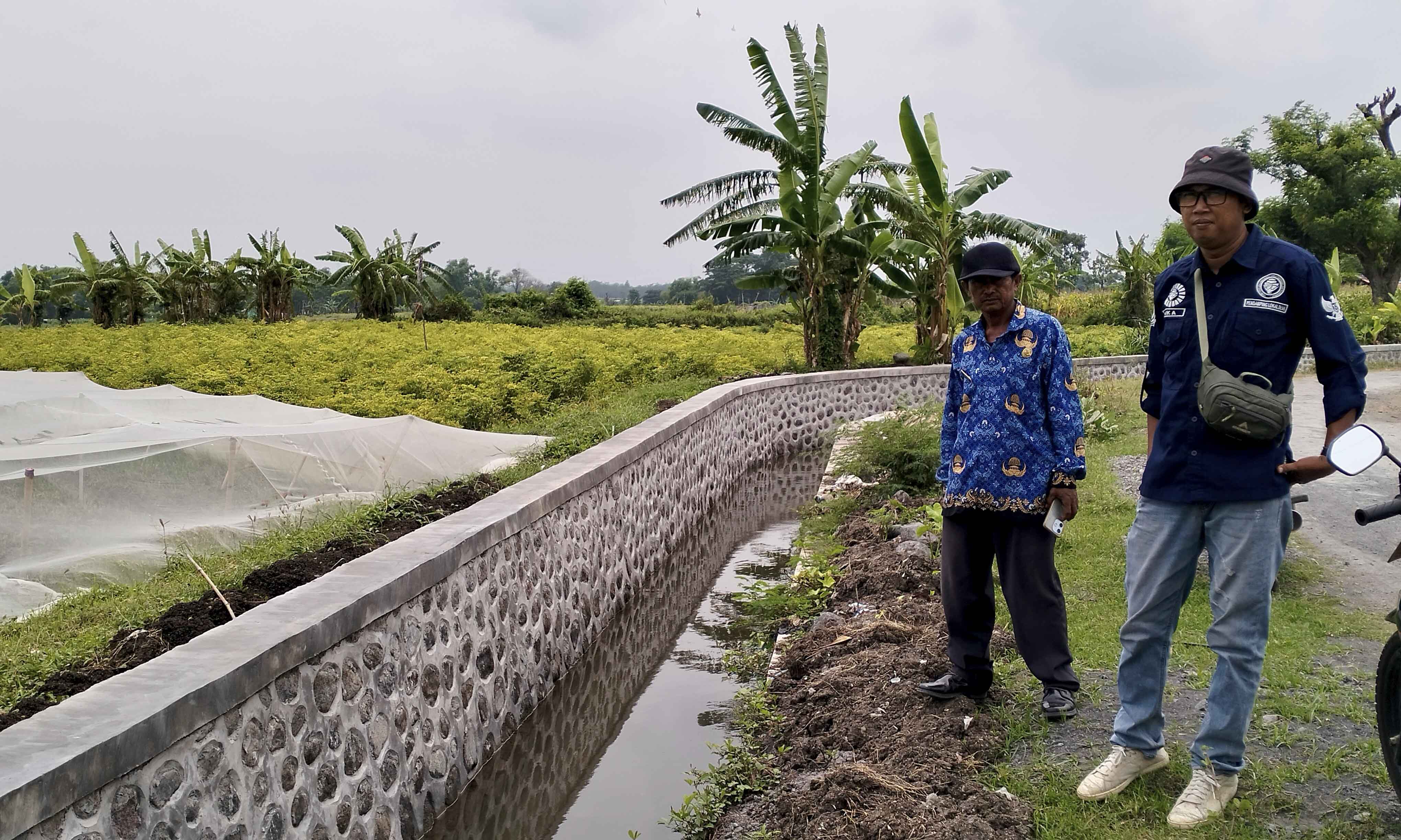 KOKOH: Kepala Desa Sekarkare Senadi (batik korpri) bersama PLD Sekarkare Abdul Rahman mengecek irigasi di RT 6/RW 2, Dusun Sekargadung, yang selesai dibangun.