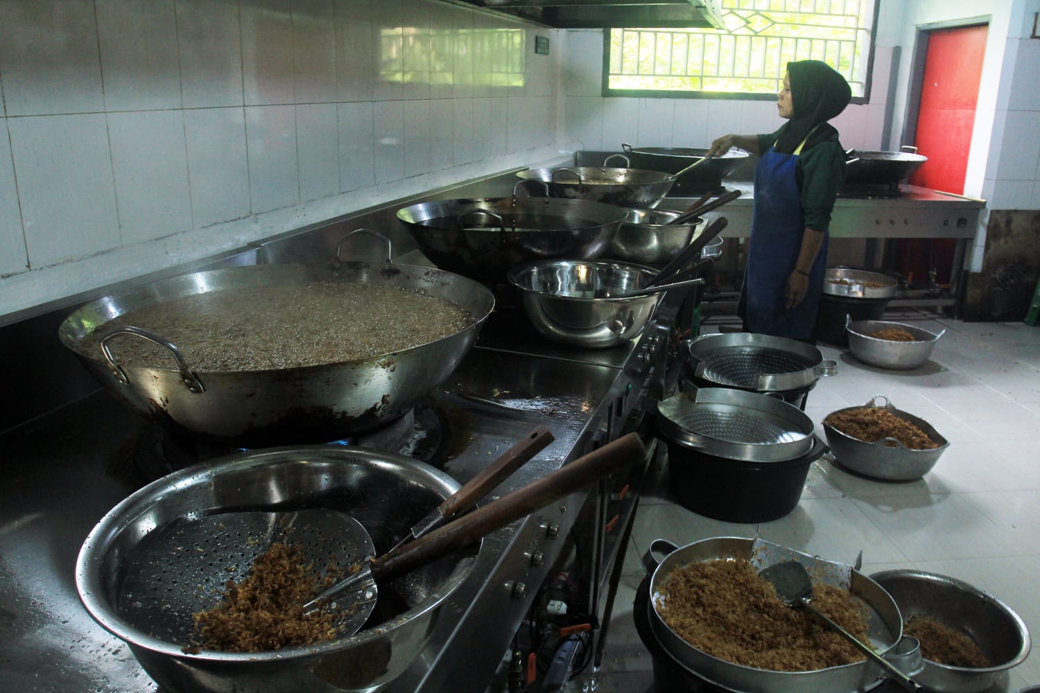 PEMBERDAYAAN : Salah satu karyawan Bawang Goreng Hunay sedang menggoreng bawang di dapur produksi.