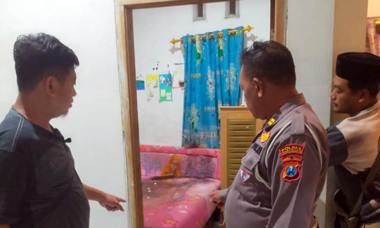 MEMILUKAN: Petugas kepolisian saat mendatangi rumah korban. Ia ditemukan tak bernyawa di dalam kamarnya.