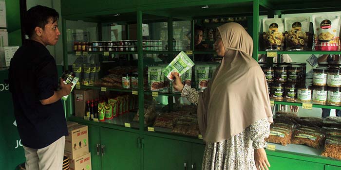 OUTLET: Owner Bawang Goreng Hunay Nurul Khotimah menunjukkan salah satu produknya kepada perwakilan BI Malang di outlet yang berada di rumahnya.