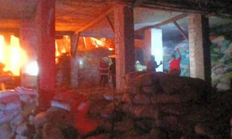 MASIH MENYALA: Petugas dan warga memadamkan api saat membakar gudang pakan ternak di Desa Trewung, Kecamatan Grati, Rabu (12/11) pagi.