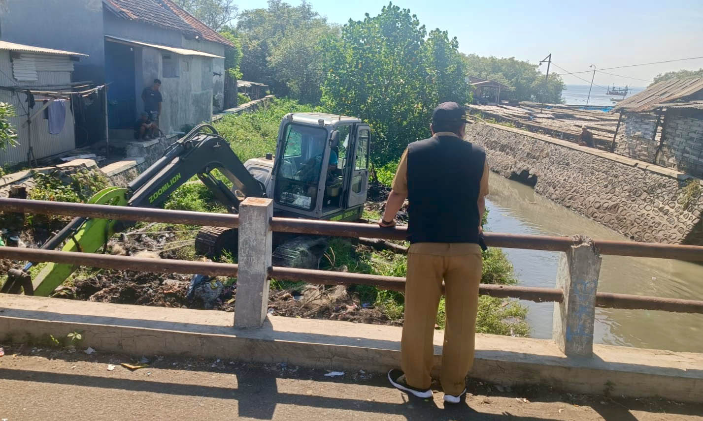 DIKERUK: Sebuah ekskavator melakukan normalisasi sungai di RT 6/RW 2, Dusun Krajan sampai RT 7/RW 3, Dusun Pesisir.