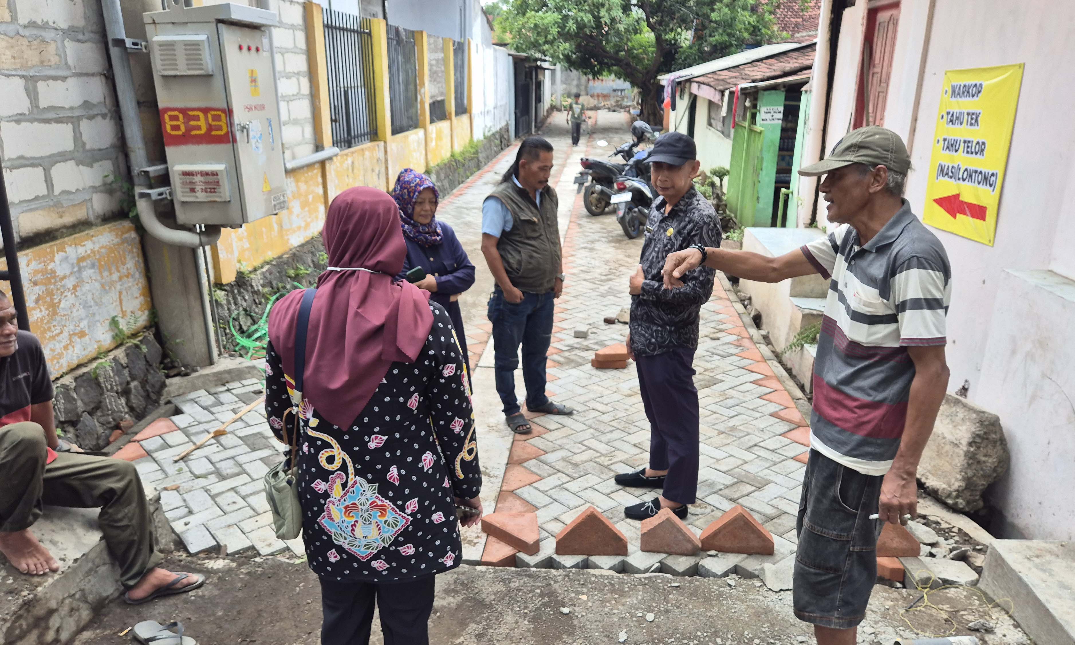 TINJAU: Kepala Dinas Perkim Kota Pasuruan, Akun Novajanto (baju batik coklat) saat meninjau lokasi rumah warga di Gang Jamu yang kebanjiran.