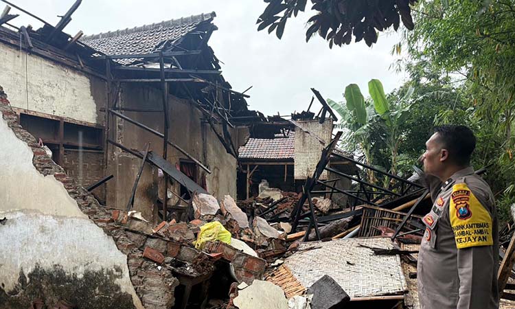 Petugas Polsek Kejayan meninjau rumah Aisah di Dusun Krajan, Desa Kepuh, Kecamatan Kejayan, Kabupaten Pasuruan, yang porak poranda kena angin kencang