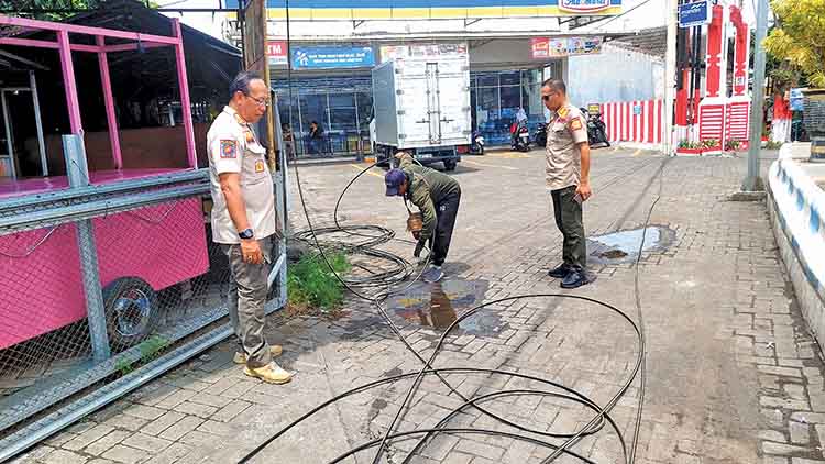 CEK LANGSUNG: Anggota Satpol PP Kota Probolinggo mengecek laporan warga mengenai pemasangan kabel dan tiang wifi di Jalan Mastrip, Kota Probolinggo, Kamis (13/11).