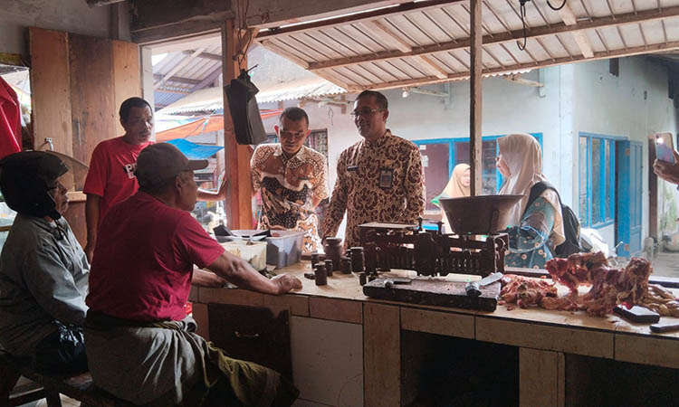 CEK DAGING: Petugas dari Dinas Pertanian sedang mengecek daging yang dijual di Pasar.