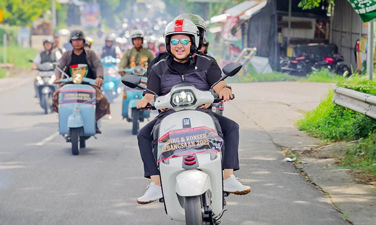 JALAN-JALAN: Bupati Pasuruan Rusdi Sutejo yang membonceng istrinya saat riding kebangsaan bersama ratusan scootermania Minggu (16/11) pagi.