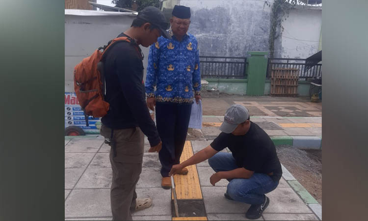 CEK LOKASI: Petugas DPKPP mengecek drainase di lokasi Alun-alun Kraksaan di sisi timur.