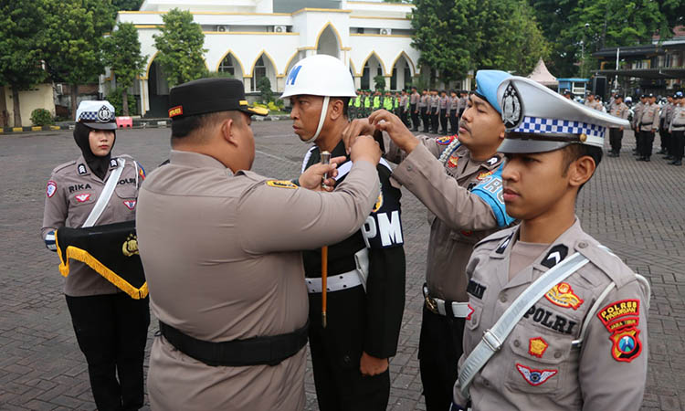 SEMATKAN: Kapolres Pasuruan AKBP Jazuli Dani Iriawan saat menyematkan pin tanda dimulainya Operasi Zebra Semeru 2025. Operasi berfokus untuk menekan pelanggaran dan kecelakaan.