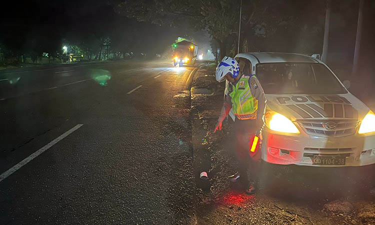 TUNJUKKAN: Petugas kepolisian saat menunjukkan lokasi kecelakaan yang menewaskan korban. Saat ini, penyelidikan masih dilakukan untuk memburu penabrak.