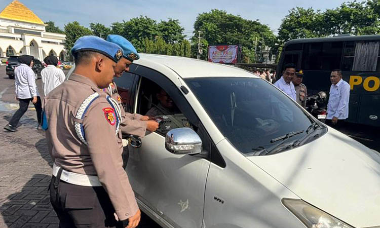 DIPERIKSA: Petugas Propam Polres Pasuruan saat melakukan pemeriksaan kelengkapan dokumen diri dan kelengkapan kendaraan.