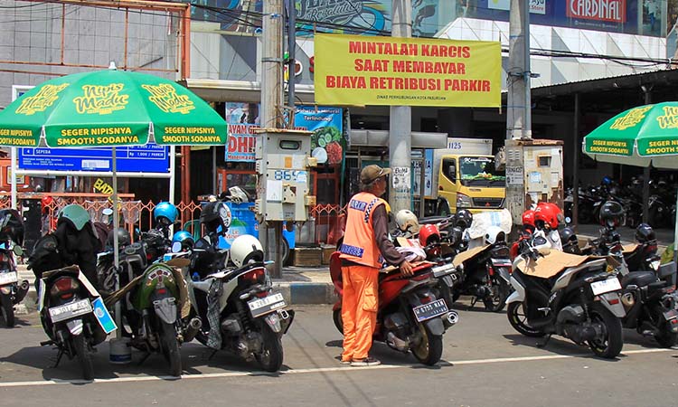 DONGKRAK PAD: Banner pengumuman pada warga agar meminta karcis saat parkir yang terpasang di kawasan Alun-alun Pasuruan.