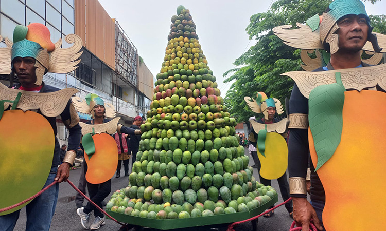 KIRAB: Gunungan mangga khas Kota Probolinggo dikirab dengan diiringi tarian dan musik Dukduk, di Jalan dr. Soetomo menuju GOR Ahmad Yani, Sabtu (22/11). (Inneke Agustin/ Radar Bromo)