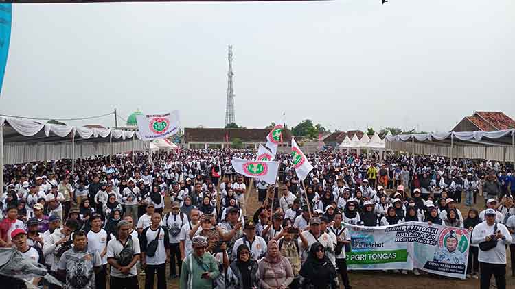 ANTUSIAS: Ribuan guru peserta Jalan Sehat HUT PGRI Ke-80 dan HGN 2025 memenuhi lapangan di Desa Curahsawo, Kecamatan Gending.