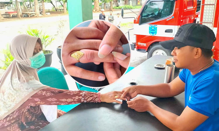 SAMPAI BENGKAK: Personel damkar mencoba melepas cincin di jari Rahmi, Minggu (23/11) sore.