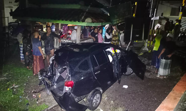 JADI TONTONAN: Warga sekitar lokasi kejadian melihat mobil seusai kejadian.
