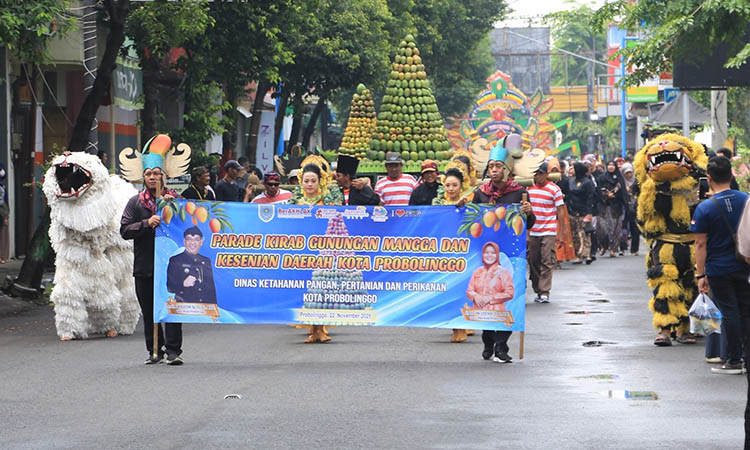 GUNUNGAN: Mengawali rangkaian kegiatan, dua gunungan Mangga dikirab menuju lokasi venue GOR Ahmad Yani kota Probolinggo diiringi kesenian musik Dug-dug dan Macanan, Sab
